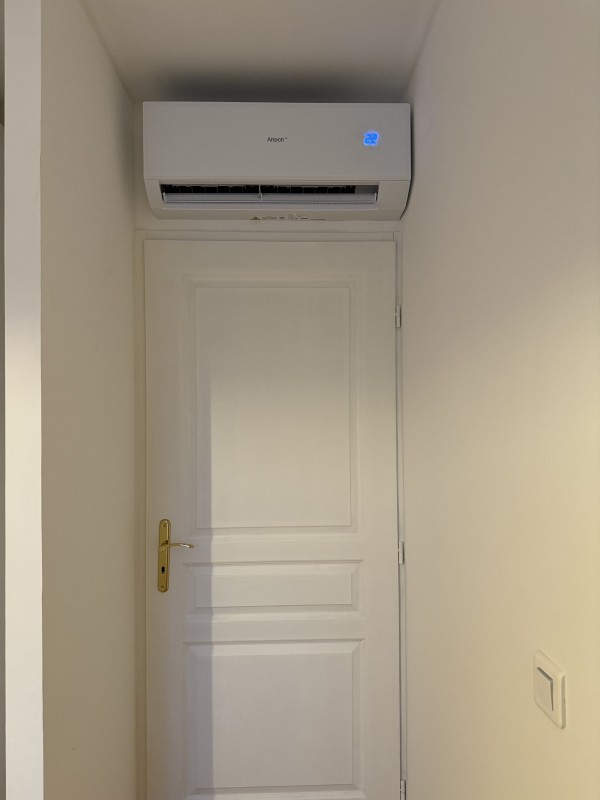 Installation de climatisation réversible ALTECH bisplit dans une chambre.